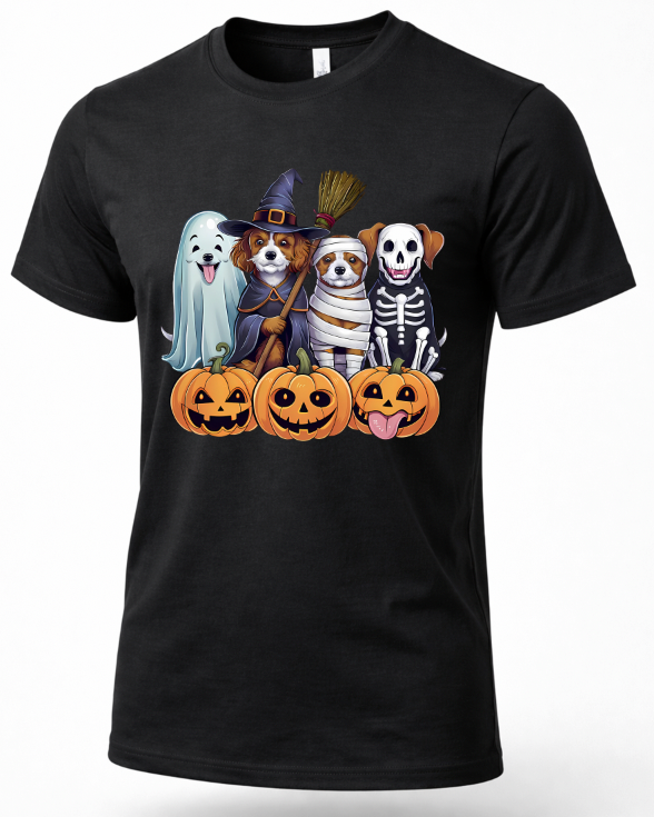 A black short-sleeve crewneck t-shirt featuring a colorful graphic print of four dogs dressed in Halloween costumes (ghost, witch, mummy, skeleton) standing behind three jack-o'-lantern pumpkins.