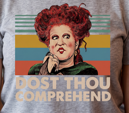 A close-up of a heather gray t-shirt featuring a retro graphic of the character Black Beauty with red hair and the text 'DOST THOU COMPREHEND' in beige block letters.