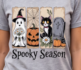 A close-up of a person wearing a gray t-shirt with a Halloween graphic print. The graphic features four vertical panels showing a witch ghost, a jack-o'-lantern, a black cat with a flower, and a tombstone, with the text 'Spooky Season' below.
