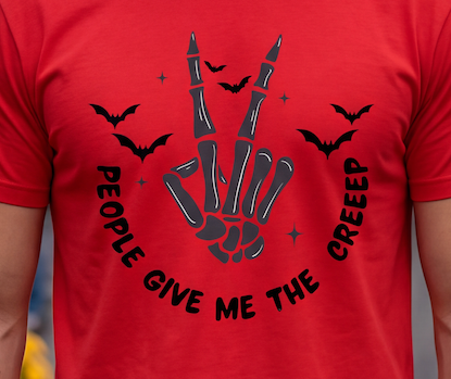 A close-up of a red short-sleeve T-shirt worn by a person, featuring a black graphic of a skeletal hand making the peace sign with bats and the text 'PEOPLE GIVE ME THE CREEEP' curved around it.