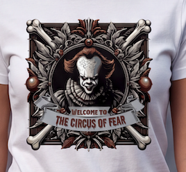 A close-up of a white T-shirt featuring a detailed graphic print of Pennywise the Clown from 'The Circus of Fear' with ornate bones and a banner reading 'WELCOME TO THE CIRCUS OF FEAR'.