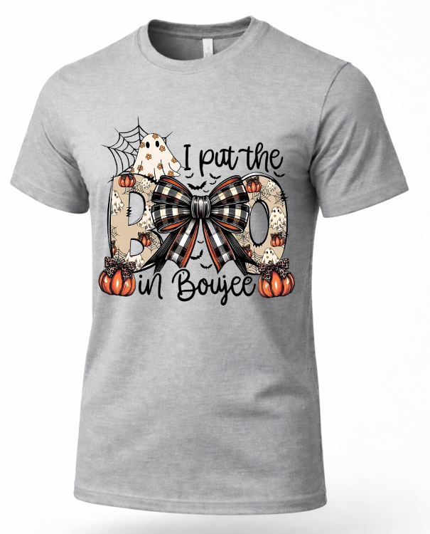 A heather gray short-sleeve crewneck t-shirt featuring a Halloween-themed graphic print on the front. The graphic reads 'I put the BOO in Boujee' with the letters styled as leopard print, black and white plaid, and patterned pumpkin motifs, accented by a ghost, spiderwebs, and small pumpkins.