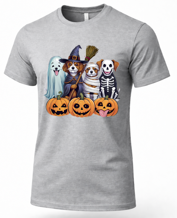 A heather gray short-sleeve crewneck t-shirt featuring a colorful graphic print of four dogs dressed in Halloween costumes (ghost, witch, mummy, skeleton) sitting behind three jack-o'-lantern pumpkins.