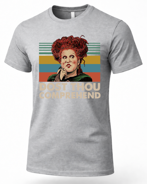 A heather gray short-sleeve t-shirt featuring a retro-style graphic of the character Hallowell from The Three Brides with red hair, set against a striped background with the text 'DUST THOU COMPREHEND'.