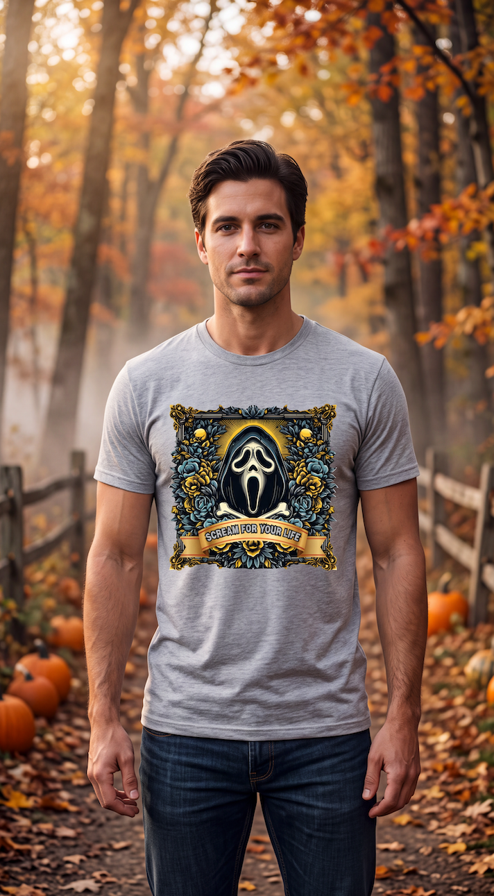 A man wearing a heather gray short-sleeve crewneck t-shirt featuring a large graphic print of the Ghostface character from Scream, framed by a gold and blue floral border with a banner reading 'SCREAM FOR YOUR LIFE'.