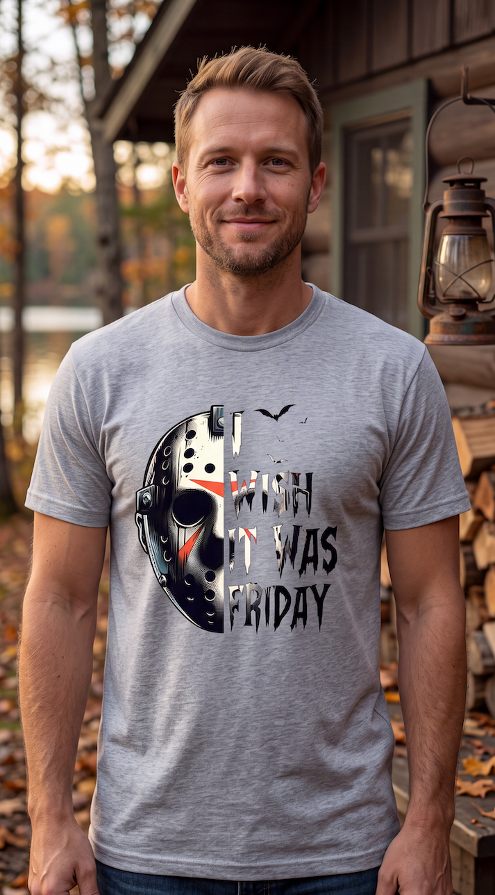 A man wearing a heather gray t-shirt with a graphic of a hockey mask and the text 'I WISH IT WAS FRIDAY' in a horror movie style, standing outdoors in front of a house porch.