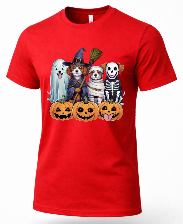 A red short-sleeve crewneck t-shirt featuring a colorful graphic of four cute dogs dressed in Halloween costumes (ghost, witch, bandage, skeleton) standing behind jack-o'-lantern pumpkins.