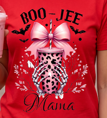 A red short-sleeve graphic T-shirt worn by a person, featuring a Halloween-themed design with the words 'BOO-JEE' and 'Mama,' a pink leopard-print cup, skeletal hands, bats, and white leaves.