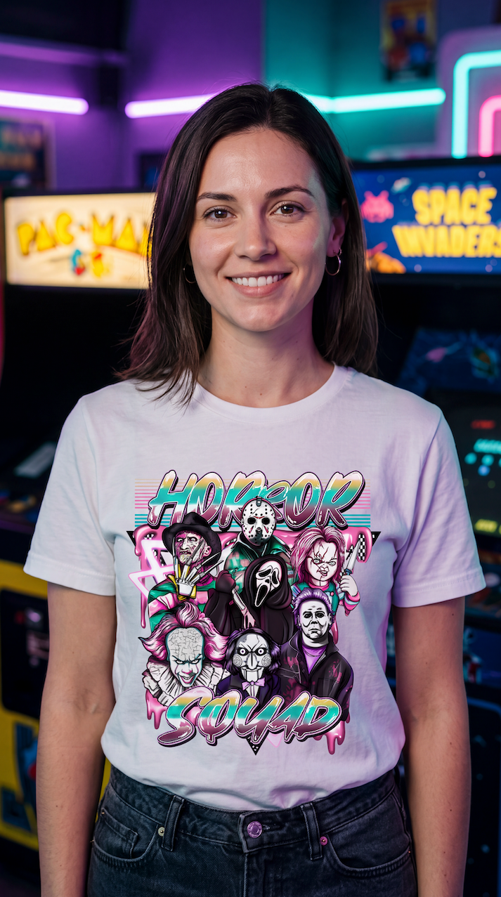 A smiling woman wearing a white graphic t-shirt with a colorful 'Horror Squad' print, standing in front of a neon-lit arcade background.