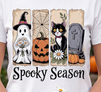 A white short-sleeve T-shirt with a Halloween-themed vertical graphic print reading 'Spooky Season.' The print shows a ghost holding daisies, a jack-o'-lantern, a black-and-white cat with a flower, and a tombstone, all on torn-paper style panels.