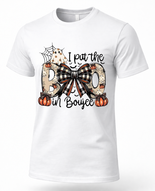 A white short-sleeve crewneck t-shirt featuring a Halloween graphic print on the front. The graphic reads 'I pat the BO in Boujee' with the letter 'O' styled as a large black-and-beige plaid bow, flanked by orange pumpkins, a spiderweb, and a small ghost.