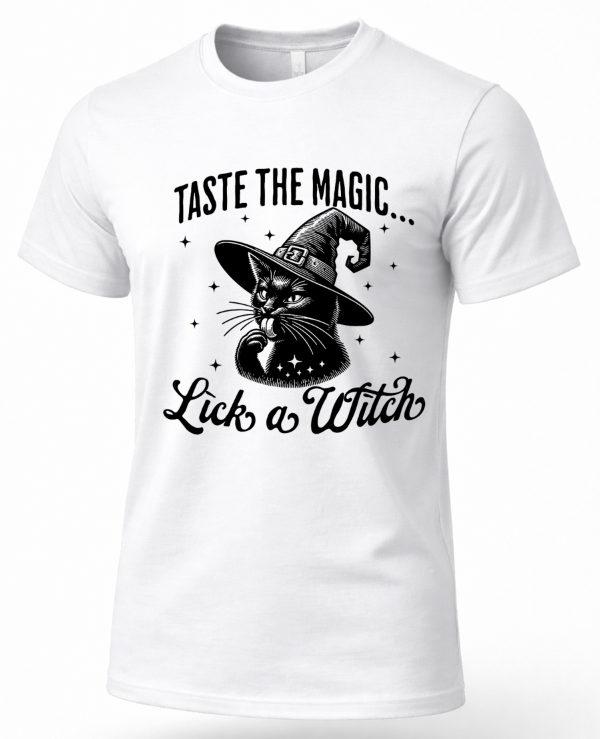 A white short-sleeve crewneck t-shirt with a black graphic print of a cat in a witch hat and the text 'TASTE THE MAGIC.