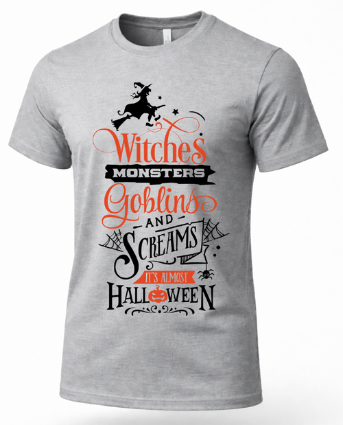A heather gray short-sleeve crewneck t-shirt featuring a Halloween graphic print with the text 'Witches Monsters Goblins and Screams I'm Always Halloween' in orange and black, along with a silhouette of a witch riding a broomstick.