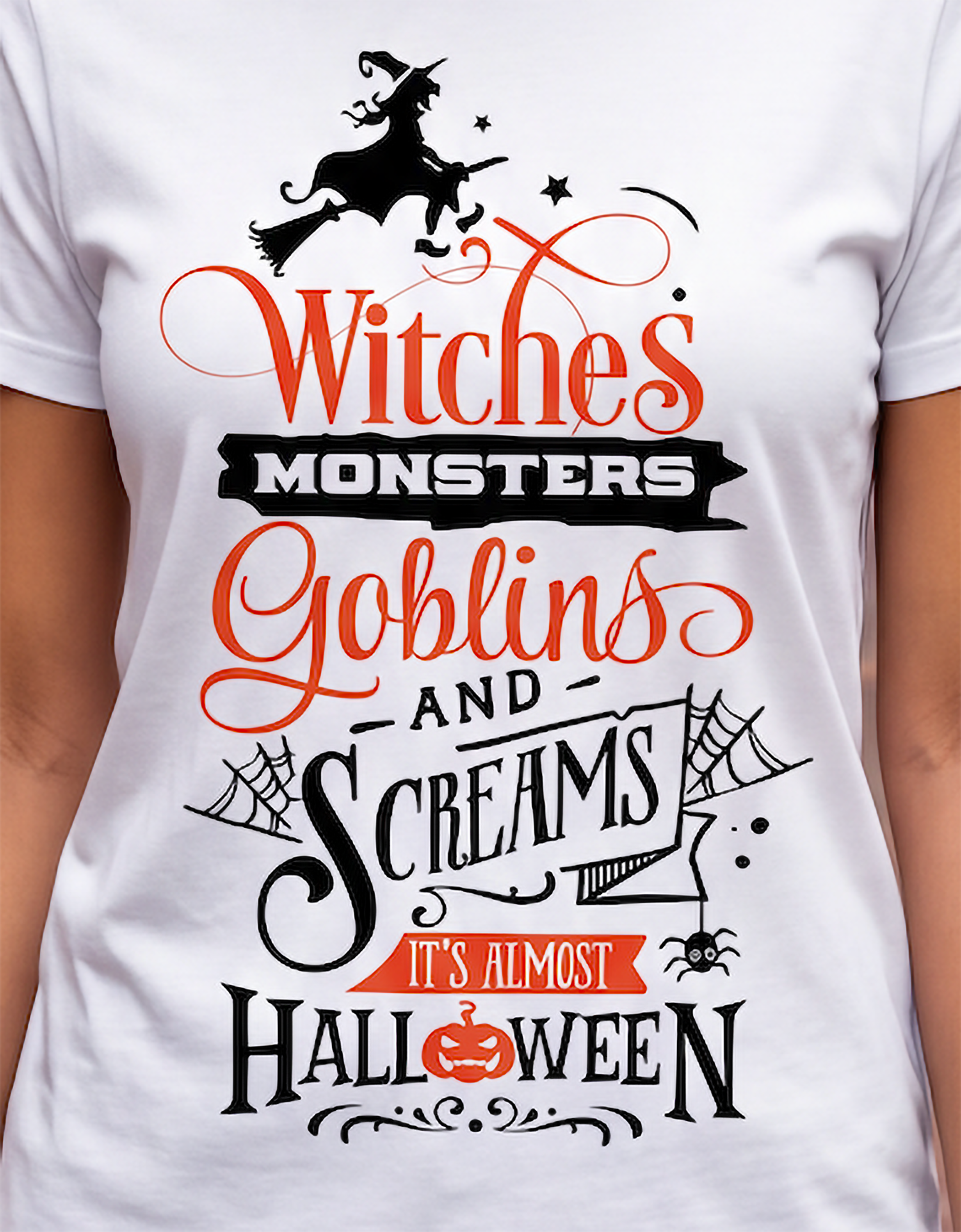 A close-up of a white short-sleeve T-shirt worn by a person, featuring a large Halloween graphic print with the text 'Witches Monsters Goblins and Screams It's Almost Halloween' in black and orange lettering, along with a witch riding a broomstick and spider motifs.