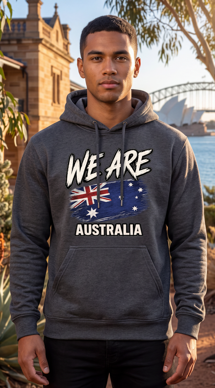 A man wearing a dark gray heather hoodie with a 'WE ARE AUSTRALIA' graphic featuring the Australian flag, standing outdoors in front of Sydney Harbour and the Sydney Opera House.