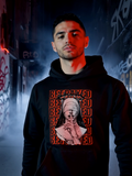 Man wearing black hoodie with “Betrayed” graphic and dark streetwear design in urban alley