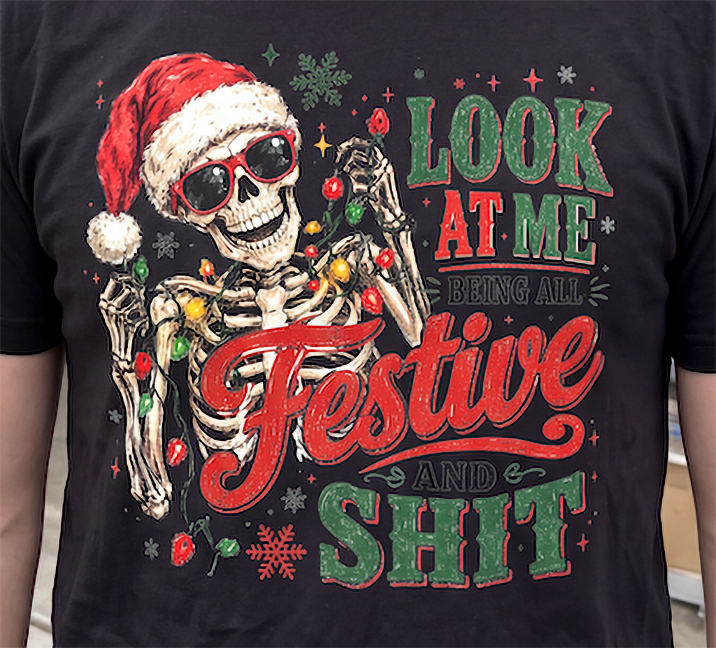 Black close-up: Close-up of Look at Me Being All Festive and Shit skeleton Christmas graphic on black shirt.