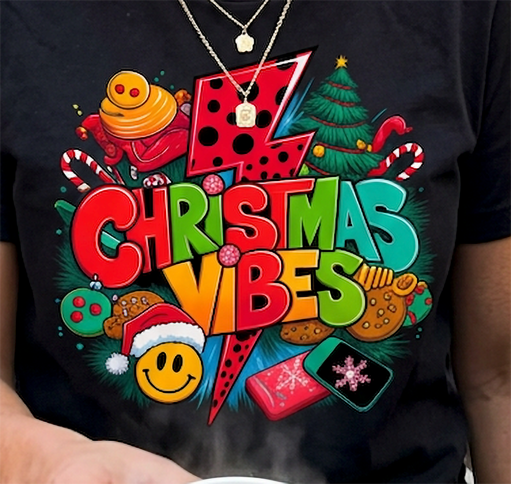 Black Design Close-Up: Close-up of vibrant retro Christmas Vibes artwork on a black t-shirt featuring colorful lettering, holiday ornaments, and a lightning bolt.