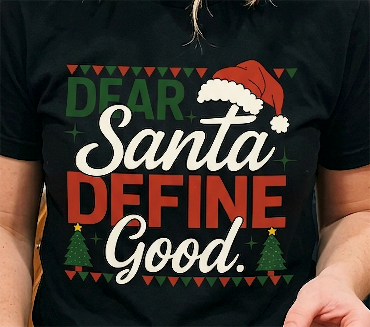 Black Close-Up: Close-up of the Dear Santa Define Good Christmas shirt design on black fabric, featuring a Santa hat and festive typography.