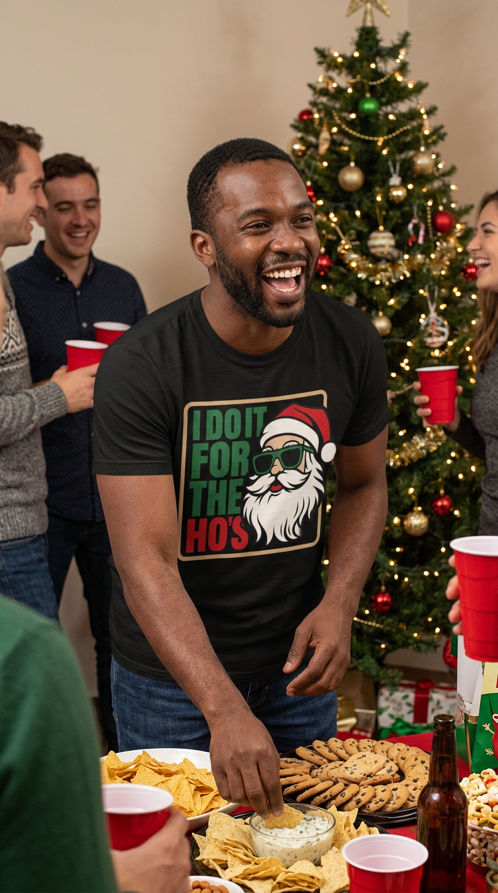 Smiling man wearing a black I Do It for the Ho's funny Santa Christmas t-shirt at a festive holiday party.