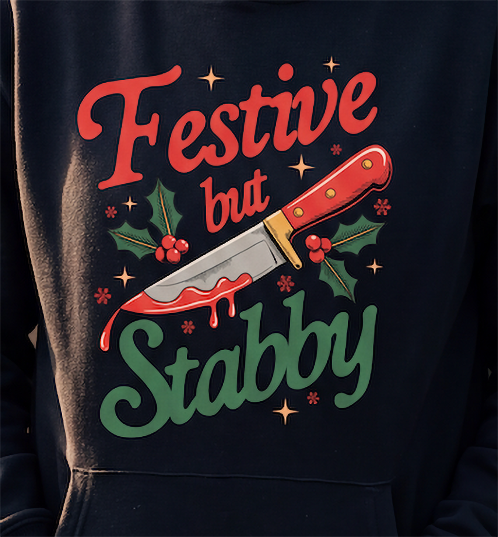 Close-up of black dark humor Christmas hoodie with Festive But Stabby design
