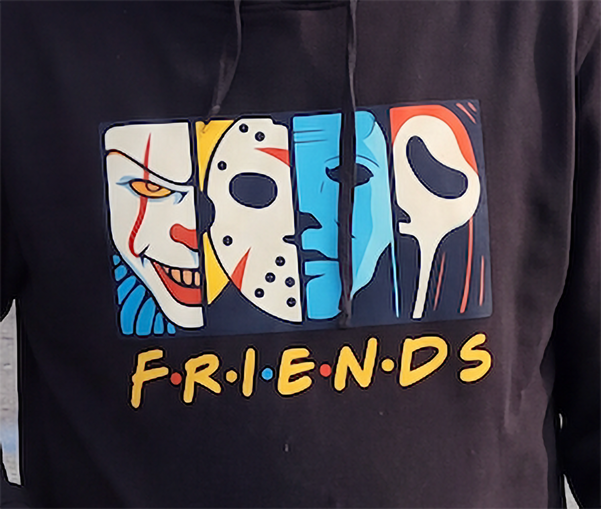 Close-up of Horror Friends graphic with four colorful horror character faces on black hoodie.