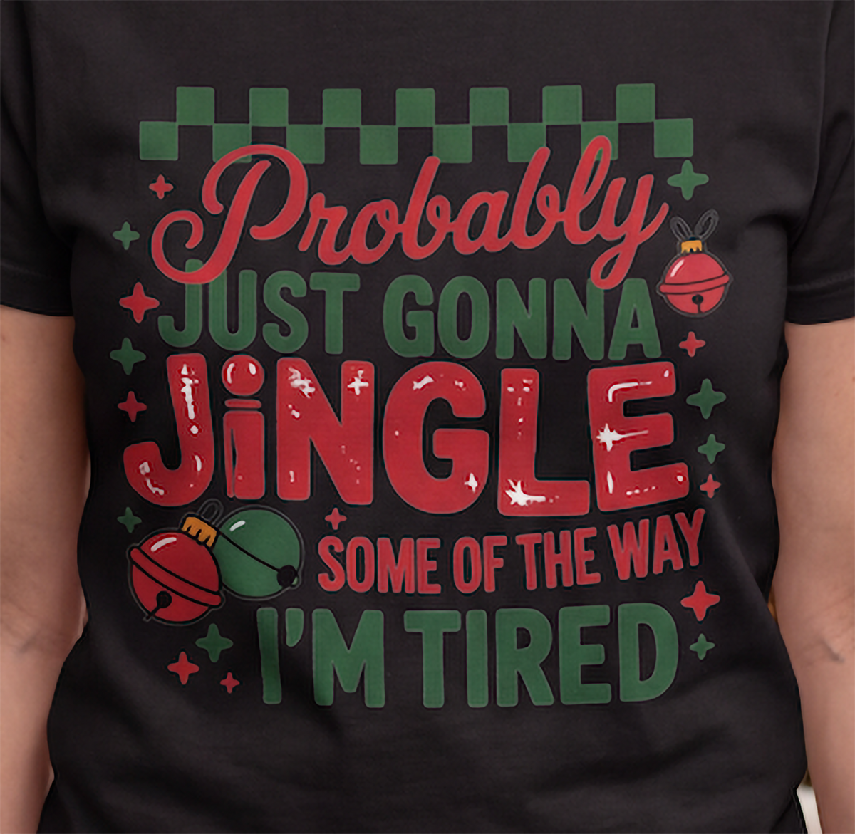 Close-up of the red and green Probably Just Gonna Jingle Some of the Way I’m Tired graphic on a black T-shirt.