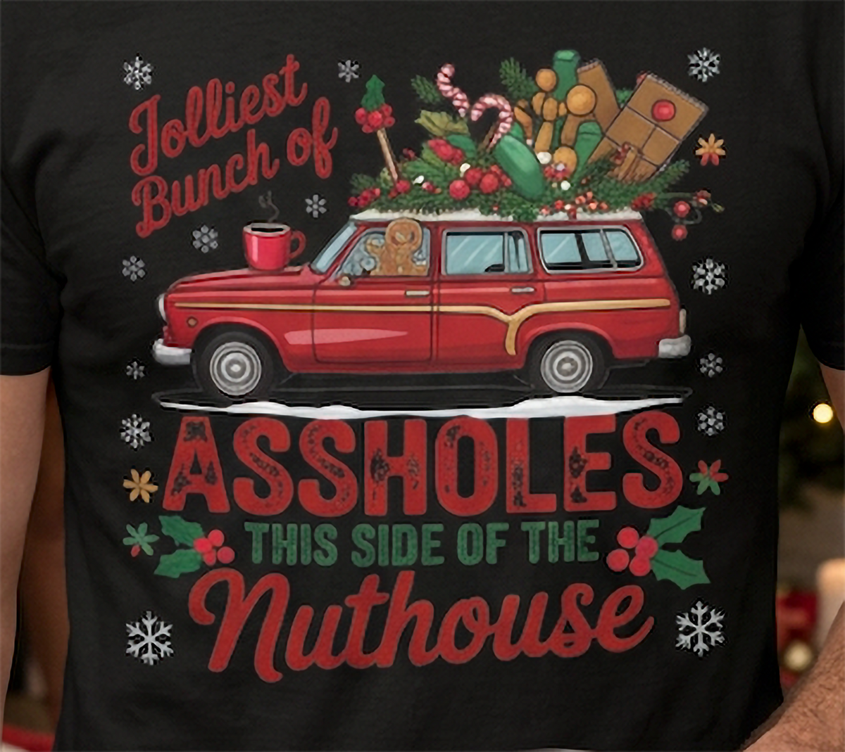 Close-up of black Jolliest Bunch of Assholes Christmas shirt graphic with red station wagon and festive details.