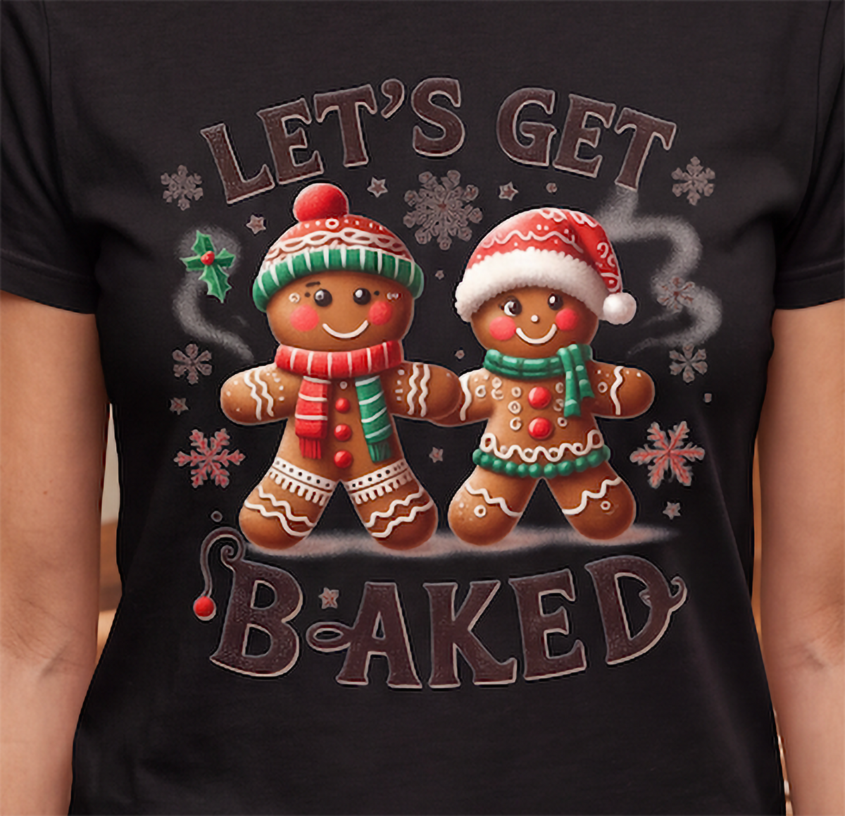 Close-up of Let’s Get Baked gingerbread Christmas graphic printed on black shirt.