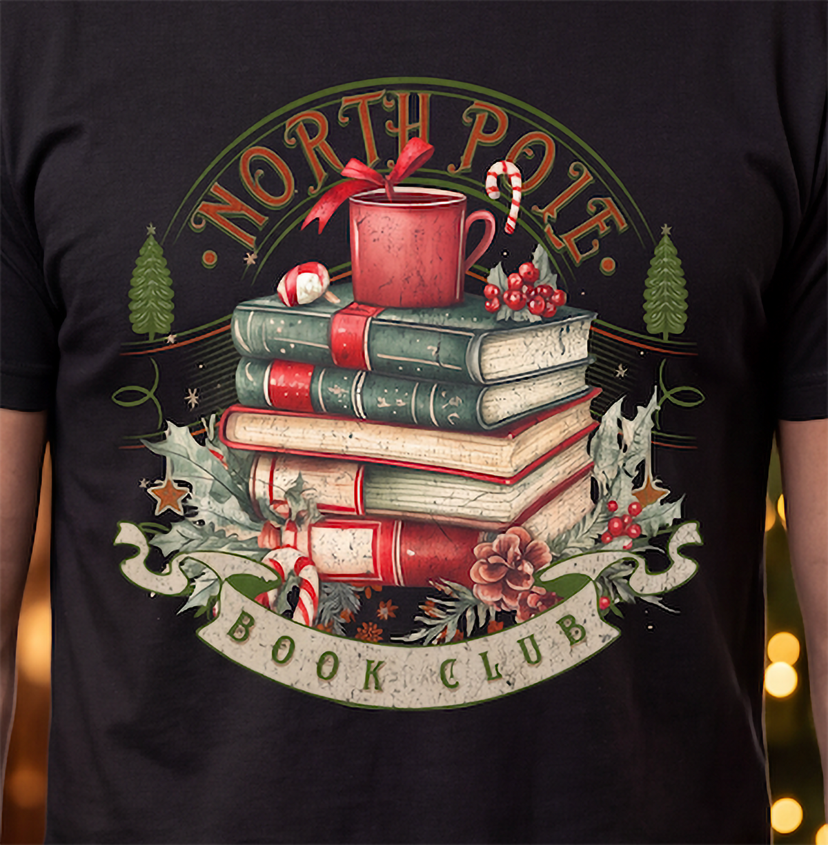 Close-up of North Pole Book Club Christmas shirt design featuring vintage books, red holiday mug, candy cane, holly and pinecones.