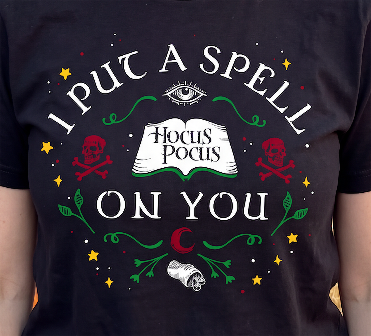 Close-up of black Hocus Pocus Halloween shirt with colorful witchy design