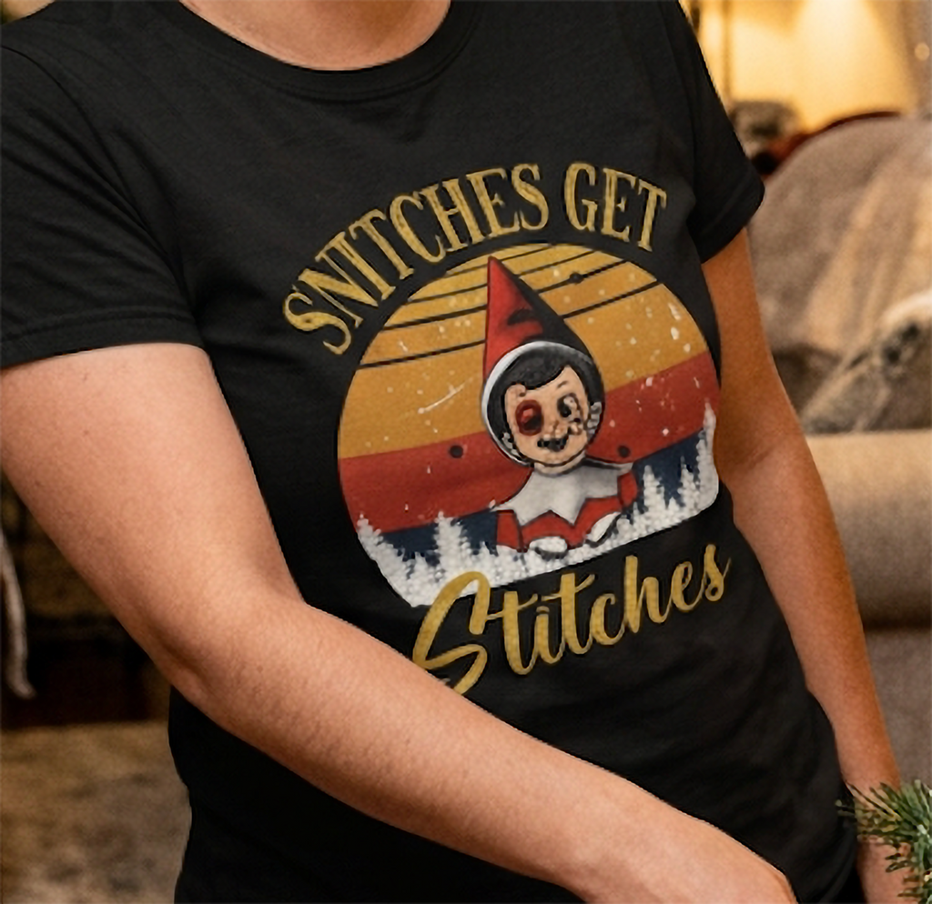 Close-up of vintage Christmas elf graphic and sarcastic Snitches Get Stitches saying on a black t-shirt.