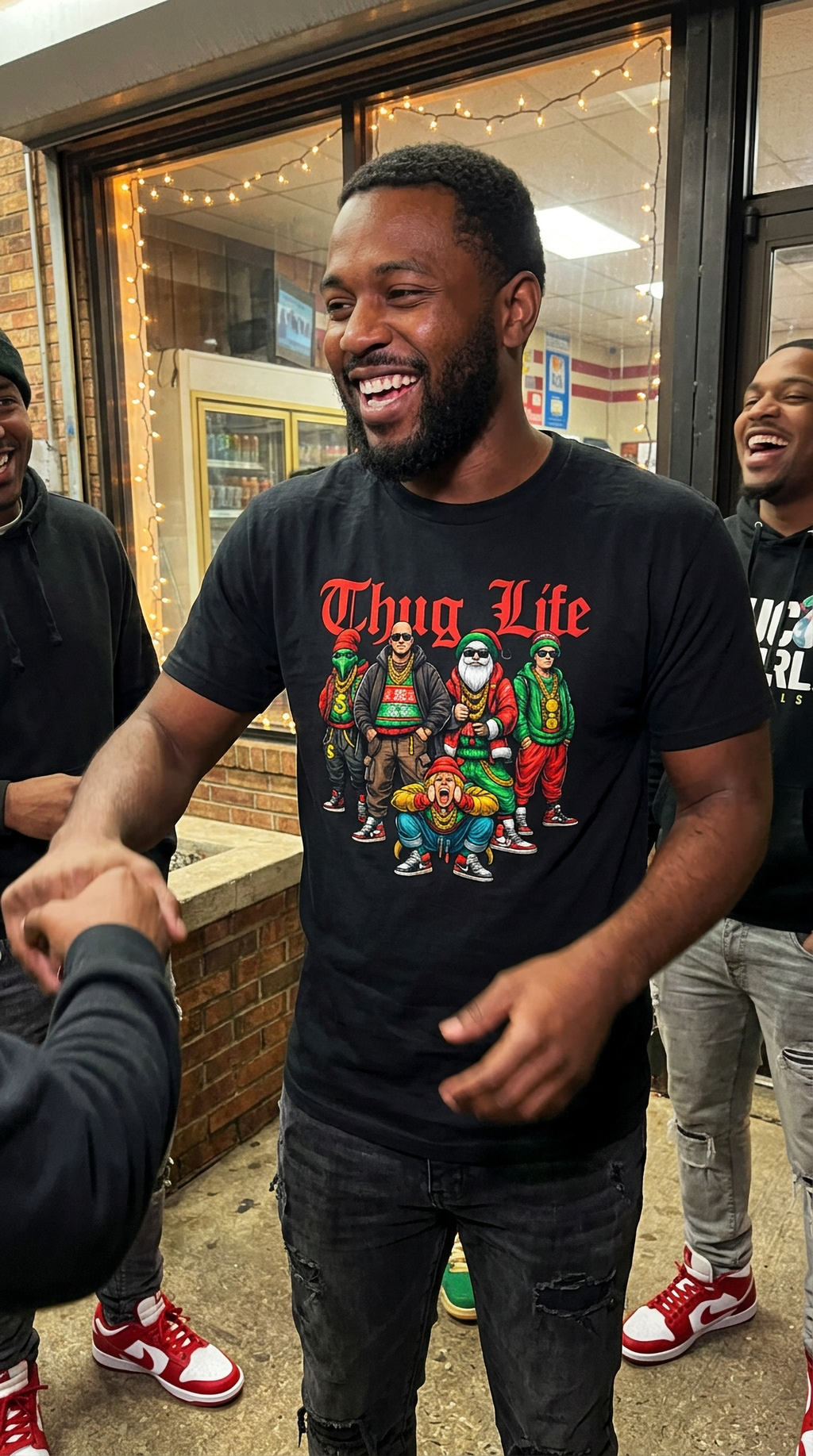 Man wearing black Thug Life Christmas graphic t-shirt featuring colorful hip hop holiday characters at a festive gathering