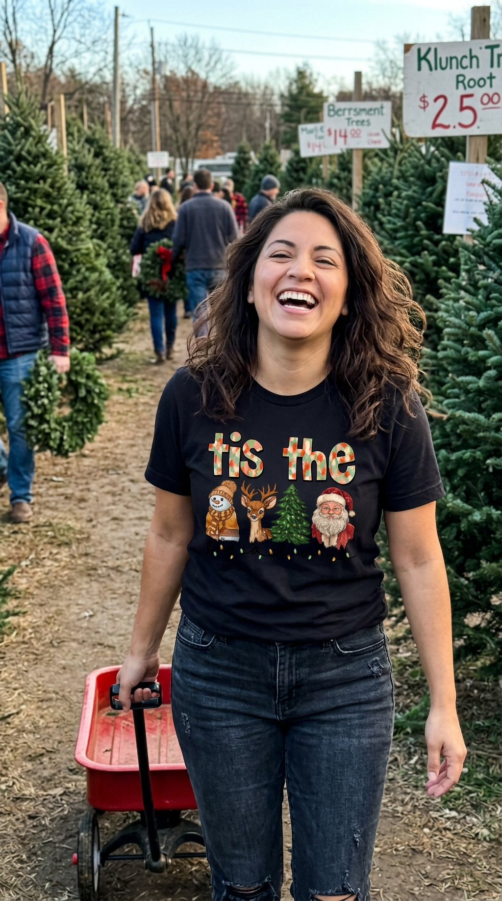 Woman wearing black Tis the Season Christmas graphic t-shirt while walking outdoors near holiday decorations and Christmas shopping displays.