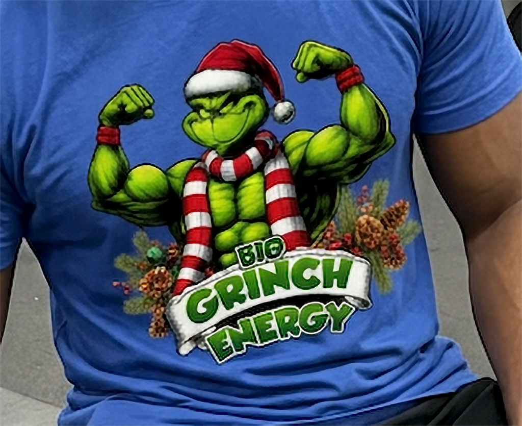 Close-up of Big Grinch Energy Christmas artwork on blue t-shirt featuring a muscular green Grinch and festive decorations.