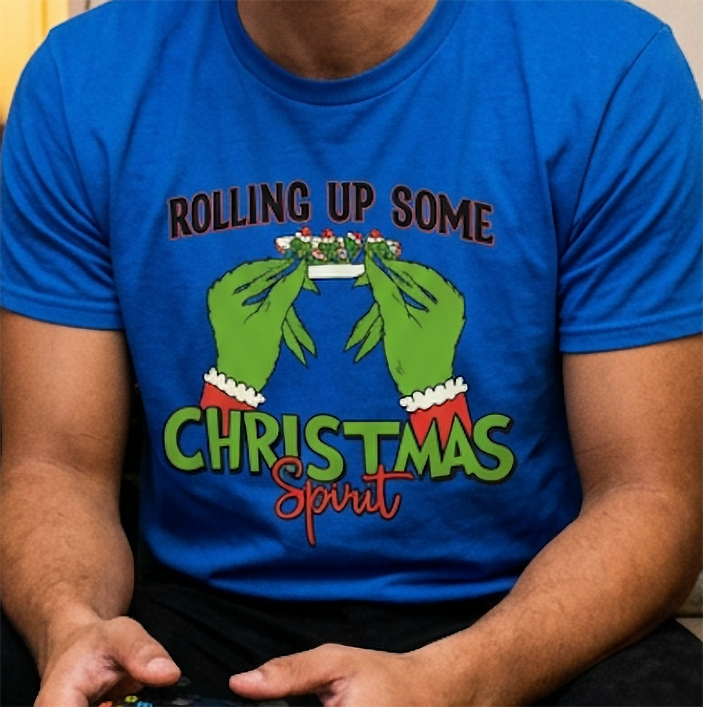 Close-up of blue stoner Christmas shirt showing green hands, red Santa sleeves, and colorful cannabis-inspired holiday design.