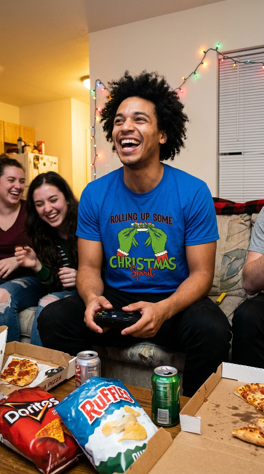 Man wearing blue Rolling Up Some Christmas Spirit graphic t-shirt at a casual indoor holiday gathering.