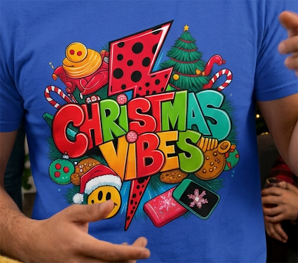 Blue Design Close-Up: Close-up of bright Christmas Vibes retro holiday artwork printed on a blue graphic t-shirt.