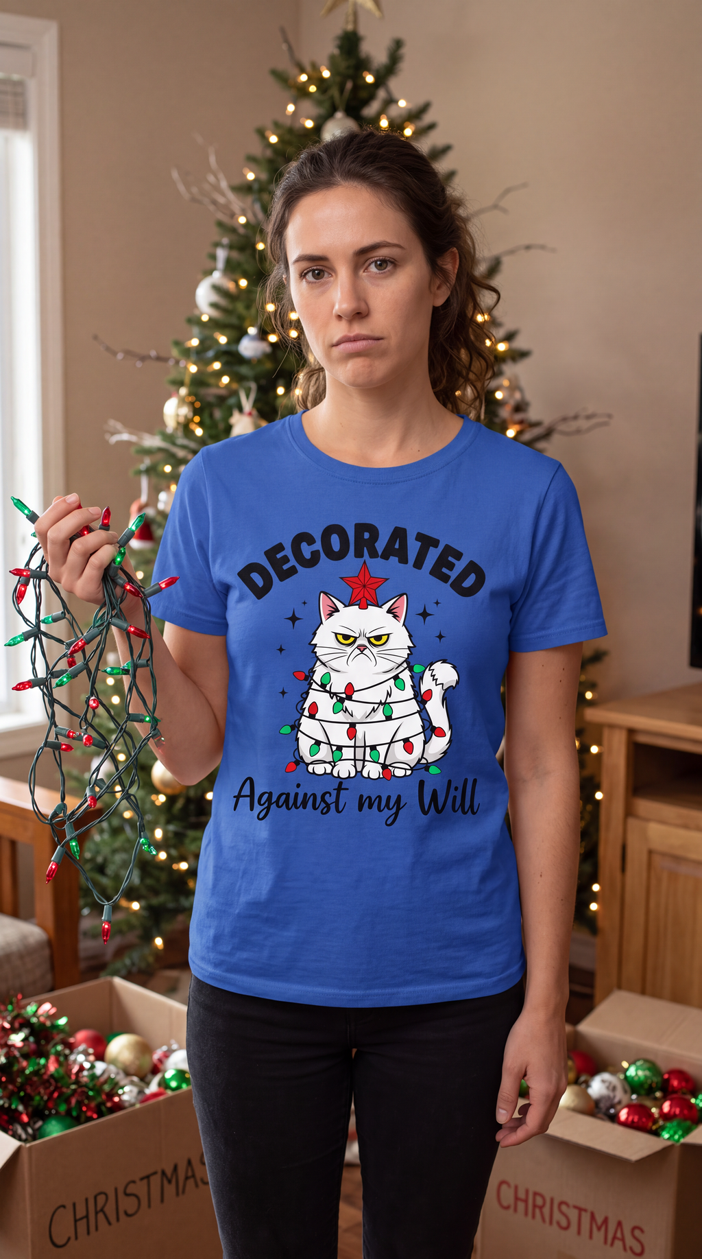 Woman wearing blue funny cat Christmas shirt featuring the Decorated Against My Will holiday design.