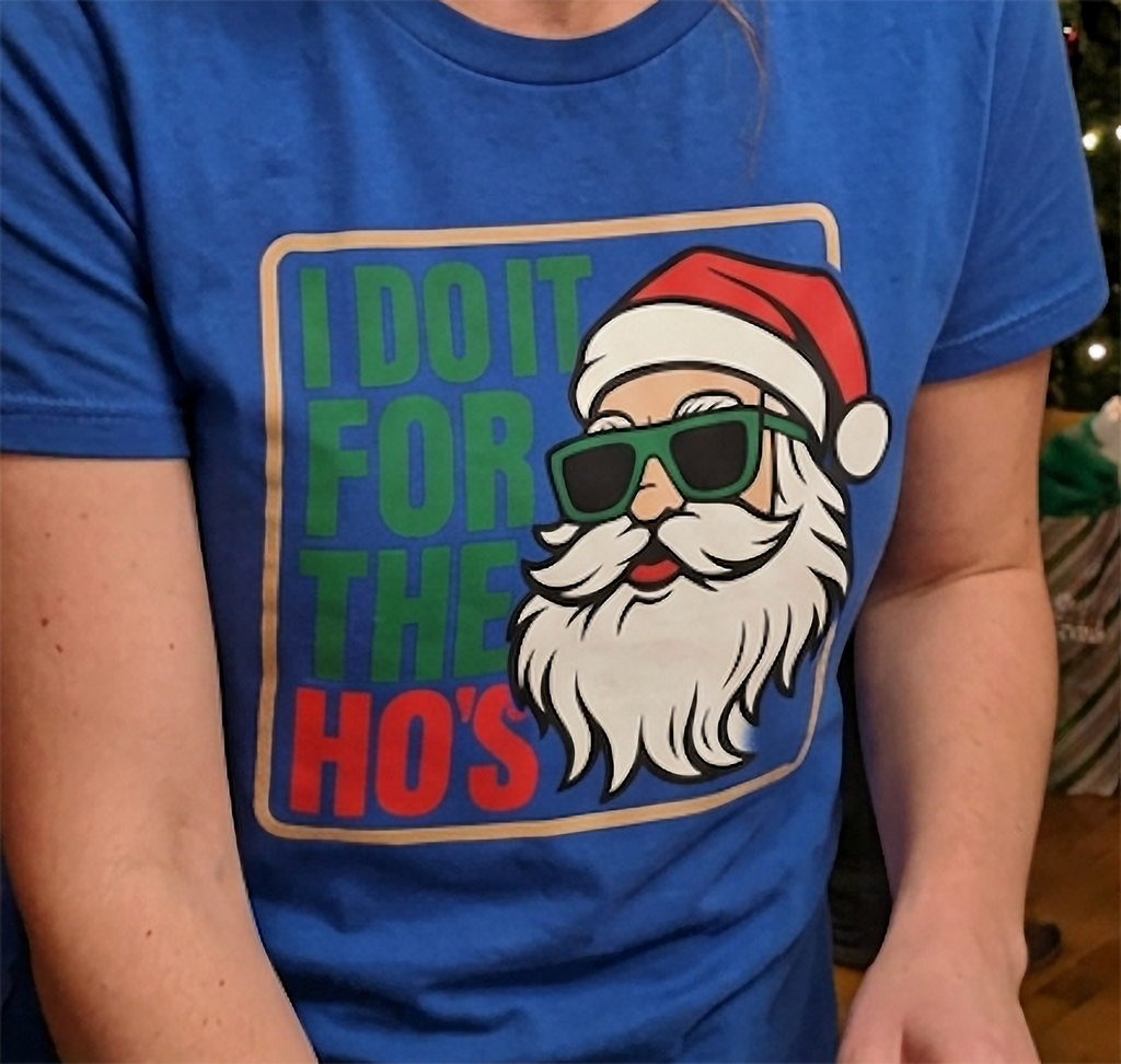Close-up of funny Santa Claus Christmas graphic with red and green lettering on a blue t-shirt.