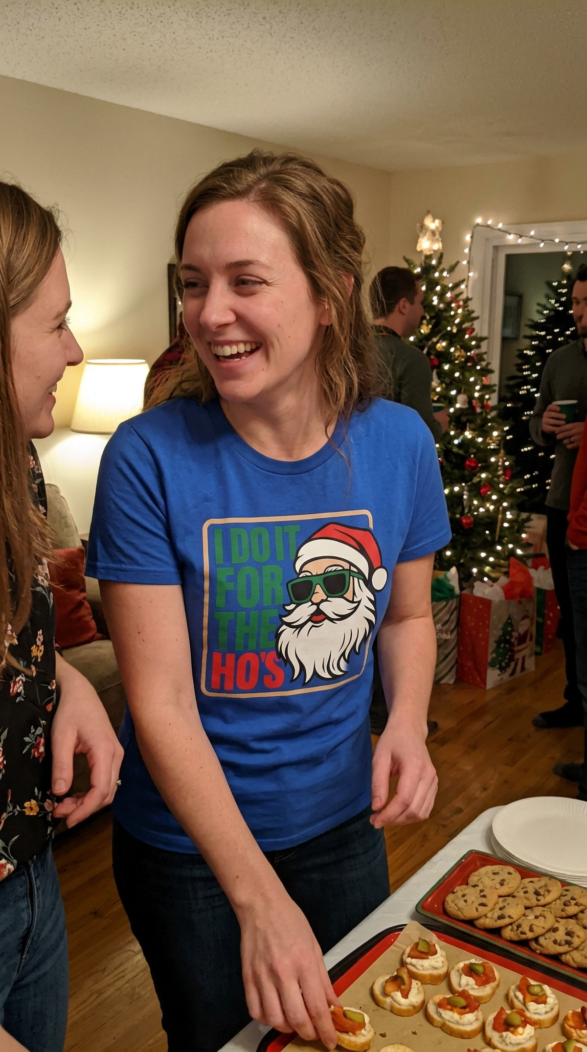 Woman wearing a blue funny Santa Christmas shirt during a holiday gathering.