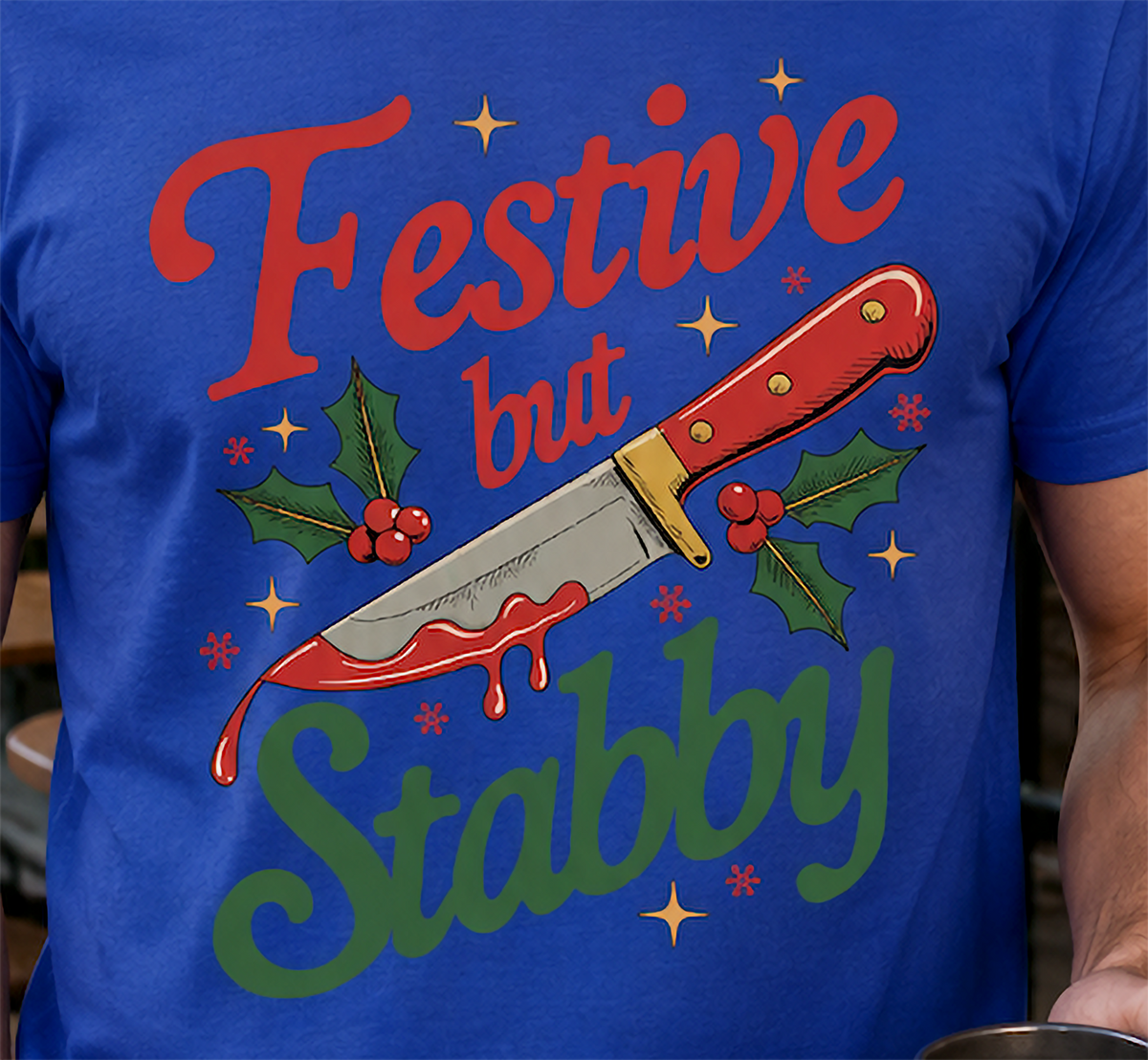 Close-up of Festive But Stabby holiday knife design on blue shirt