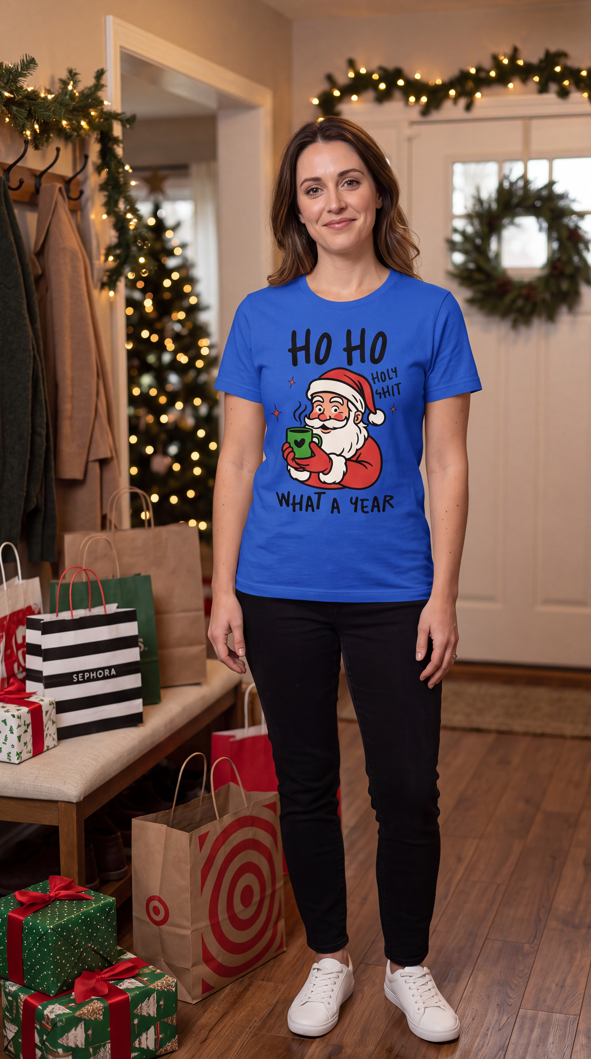 Woman wearing blue Ho Ho Holy Shit Christmas graphic T-shirt in a festive holiday setting.