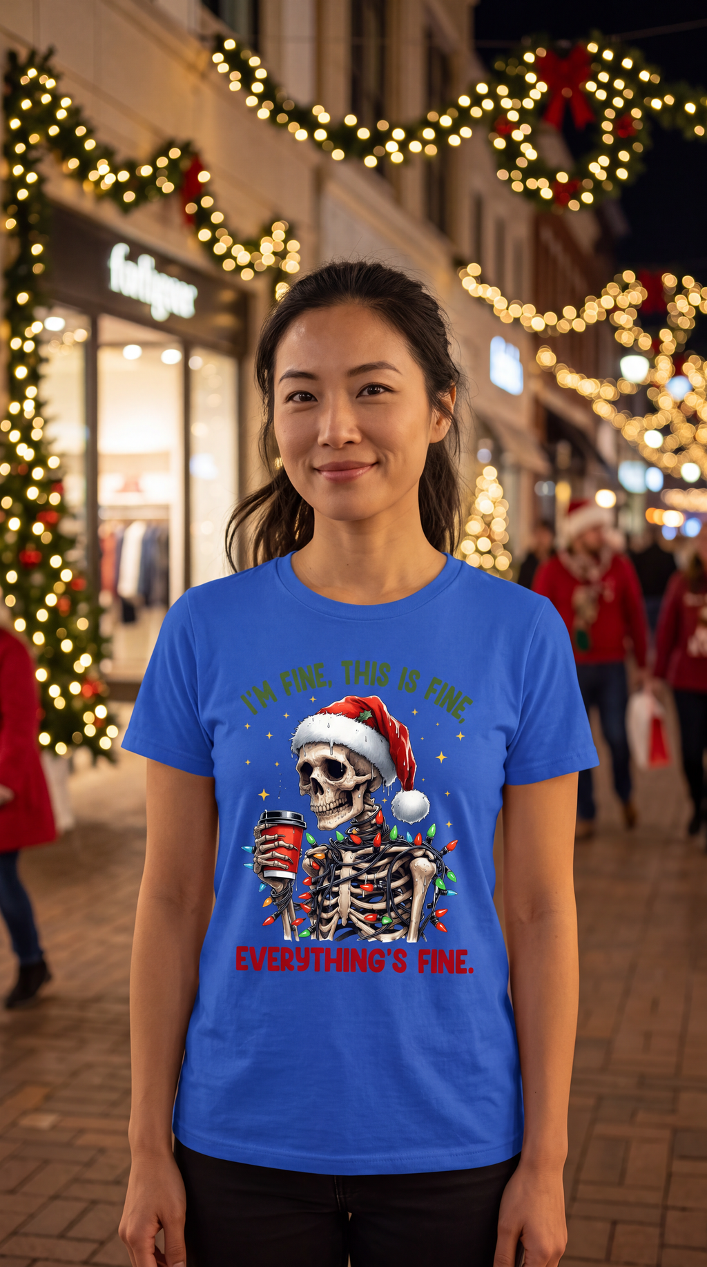 Woman wearing blue I’m Fine Everything’s Fine skeleton Christmas graphic tee in a festive holiday setting.