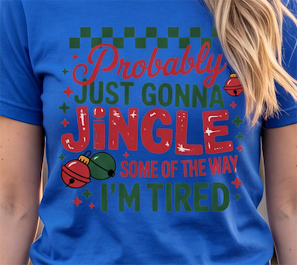 Close-up of Probably Just Gonna Jingle Some of the Way I’m Tired holiday graphic on a blue T-shirt.