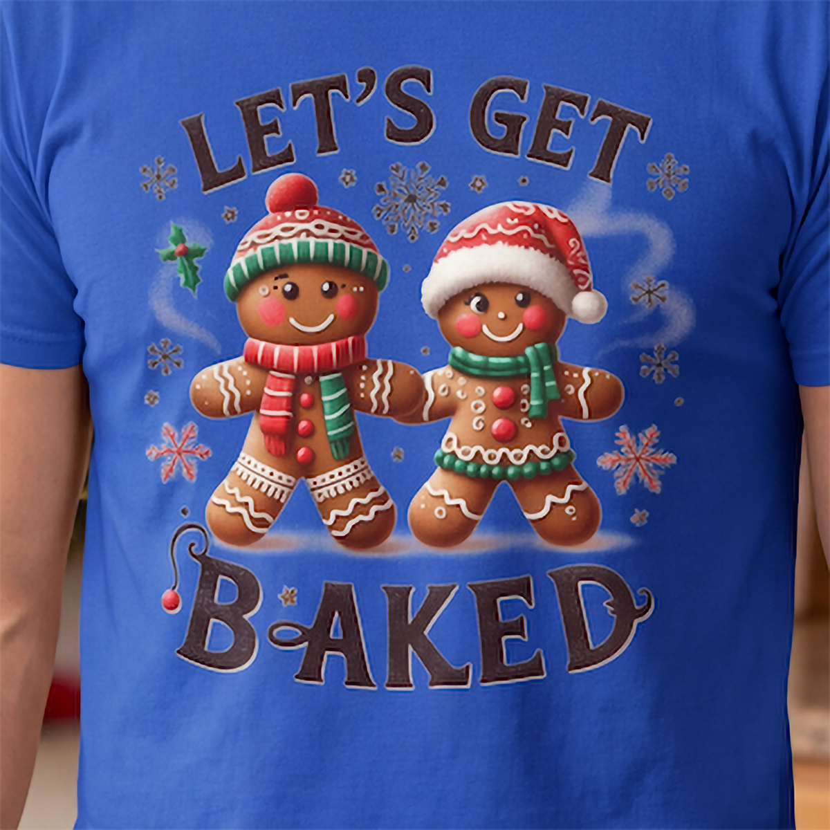 Close-up of Let’s Get Baked gingerbread Christmas graphic printed on blue shirt