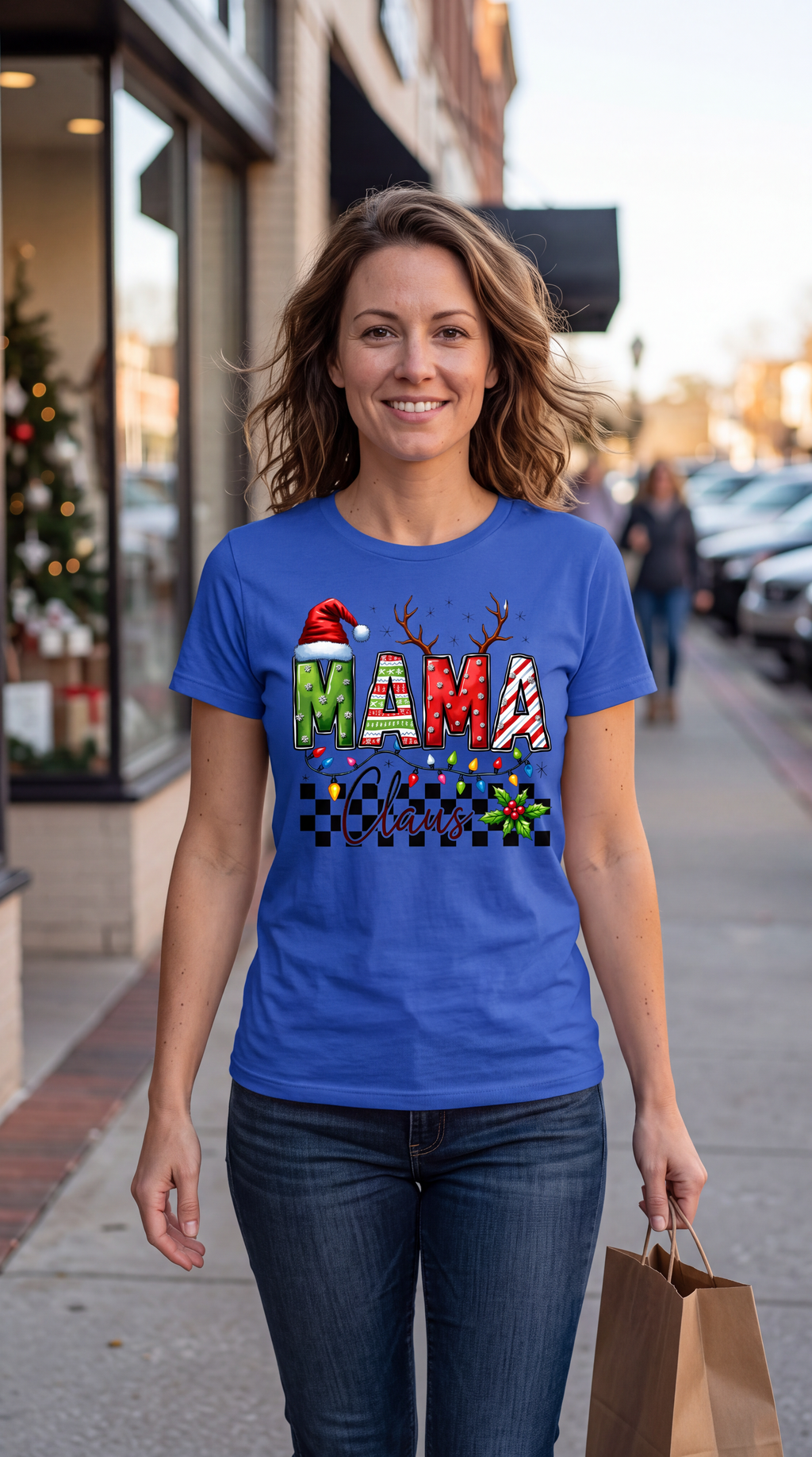 Woman wearing blue Mama Claus Christmas graphic tee in a casual indoor setting.