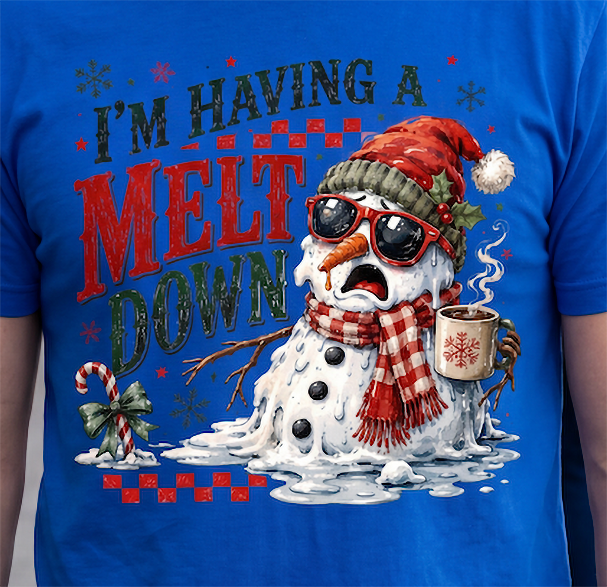 Close-up of blue I’m Having a Meltdown Christmas shirt with distressed holiday lettering and melting snowman artwork.