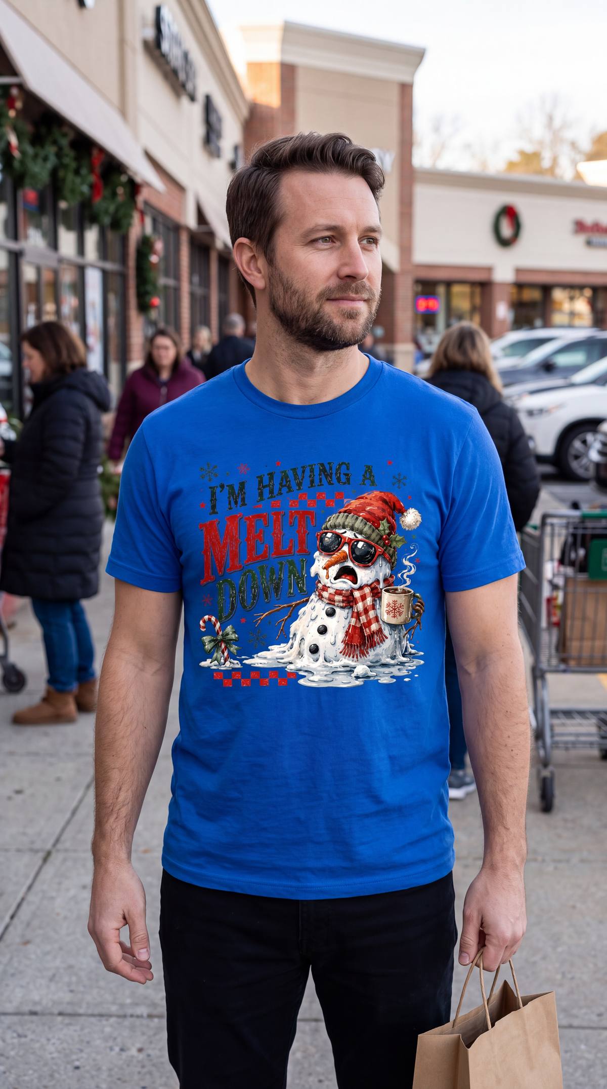 Man wearing blue I’m Having a Meltdown Christmas shirt outdoors in a casual holiday outfit.