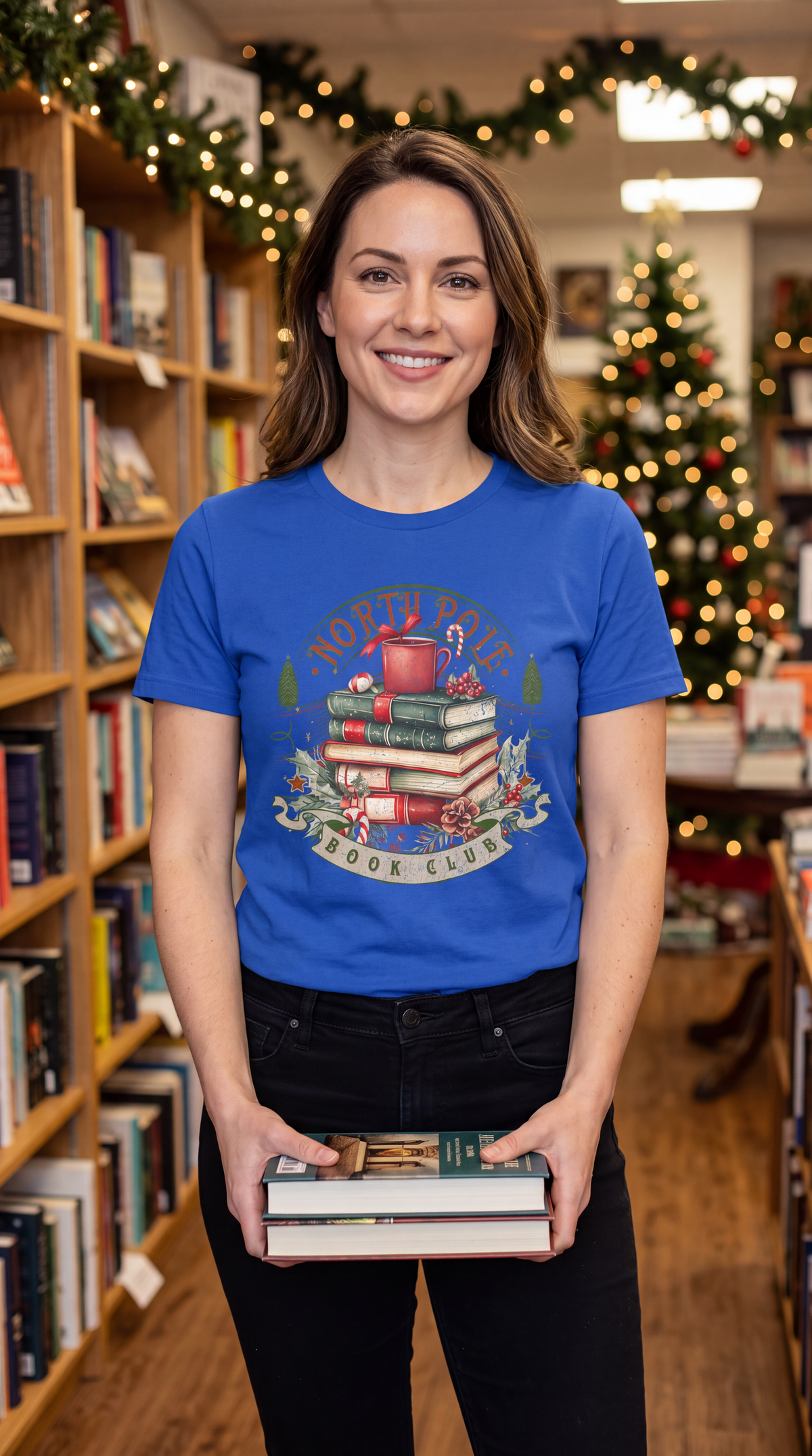 Woman wearing blue North Pole Book Club Christmas graphic tee featuring festive book lover design.